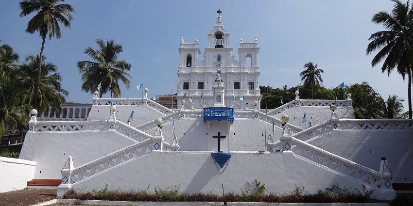 Front view of the church surrounded by tall palm trees