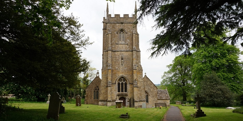 A picture of a majestic Church built using traditional architecture, with a garden area in front