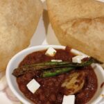 Delicious chole bhature garnished with green chilli, one of the most favourite street food in Lajpat nagar