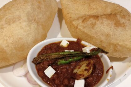 Delicious chole bhature garnished with green chilli, one of the most favourite street food in Lajpat nagar