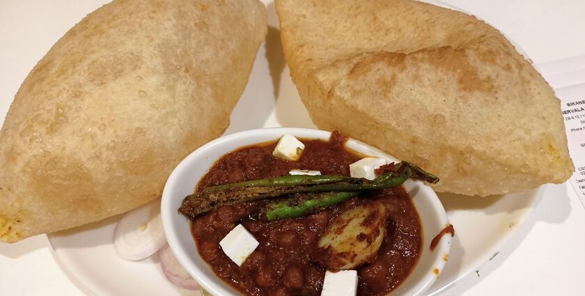 Delicious chole bhature garnished with green chilli, one of the most favourite street food in Lajpat nagar