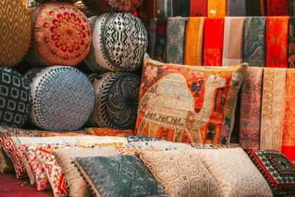 A view of cushions and pillows made up of raw silk and adorned with intricate designs.