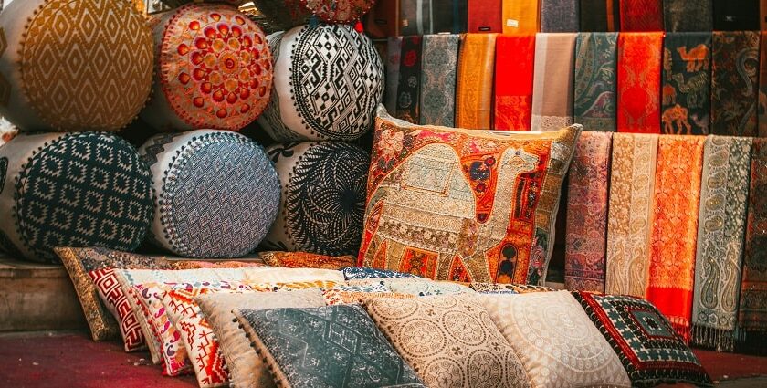 A view of cushions and pillows made up of raw silk and adorned with intricate designs.