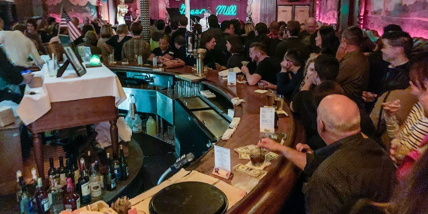 A picture of an ambient nightclub in Nana Plaza with people enjoying drinks and food