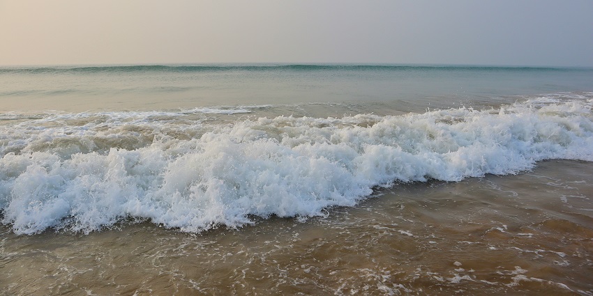 Puri Beach with waves along with textured sand patterns near Sadam Sand Art Museum.