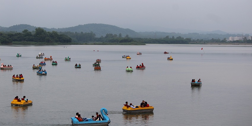 Panoramic view of the Sukhna lake and the group of people riding many colorful boats in the lake near Air force museum Chandigarh