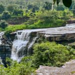 The landscape picture of the Sultan Garh Waterfalls with high mountains surrounding