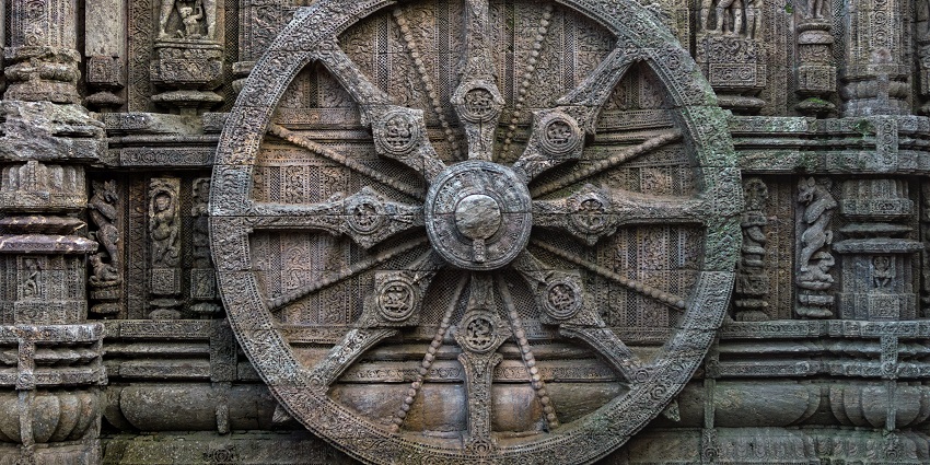 A picture of a wheel made of stone, engraved with carvings from the bygone times.