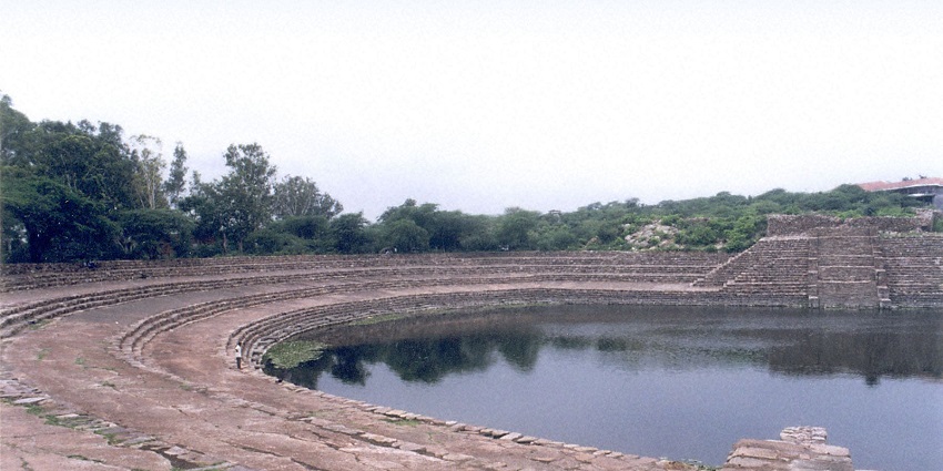 A picture of a pond with stairs surrounding it all around, one of the best weekend places near Faridabad