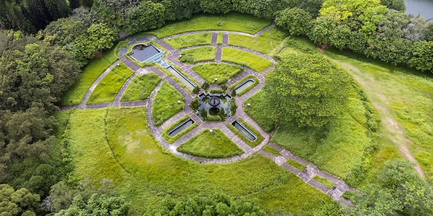 An aerial picture of a scenic park in Katni with a cover of lush greenery, and a pond in centre