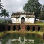 Picturesque view of the Surla mosque, with a small pond at the front surrounded by lush trees