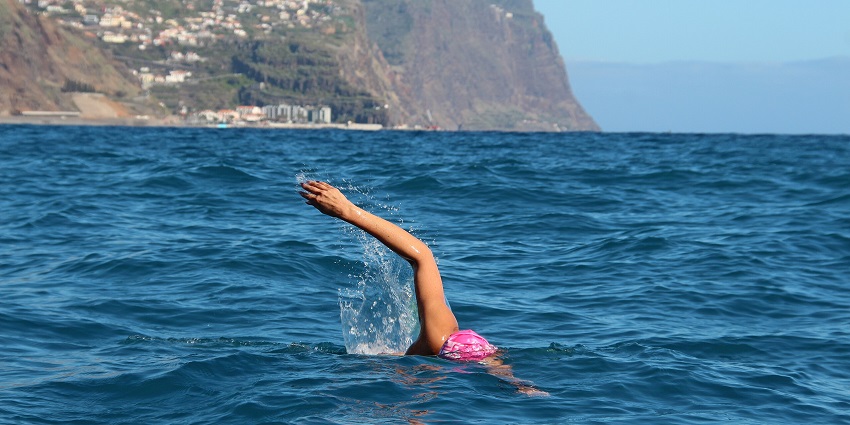 A picture of a tourist swimming in the serene blue waters around Palolem Beach