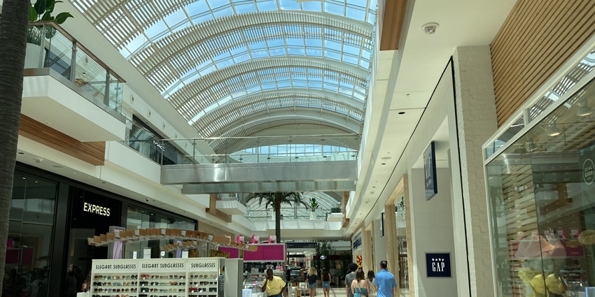 A picture of the lobby of a shopping mall with numerous stalls and stores all around