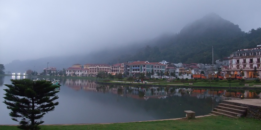 View from Ham Rong Mountain, featuring lush shores of serene Sapa lake with buildings around it