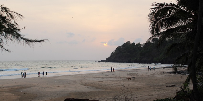 Silhouttes of people walking the serene shores of the beach