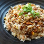 A glimpse of rice cooked with tamarind juice and served with spring onion on a plate.