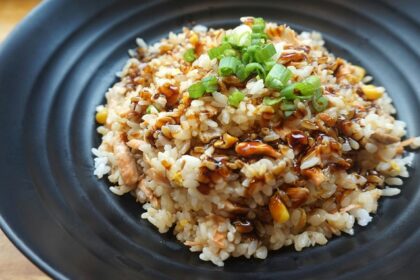 A glimpse of rice cooked with tamarind juice and served with spring onion on a plate.