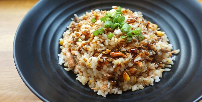 A glimpse of rice cooked with tamarind juice and served with spring onion on a plate.