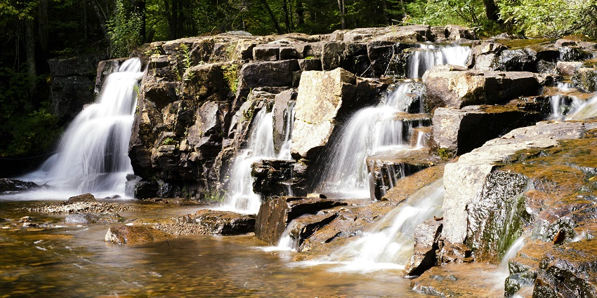 A serene view of Tambdi Surla Waterfall cascading down lush green rocks - Waterfalls In South Goa