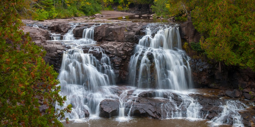 Mesmerising view of the sparkling water cascading down the rocks surrounded by greenery