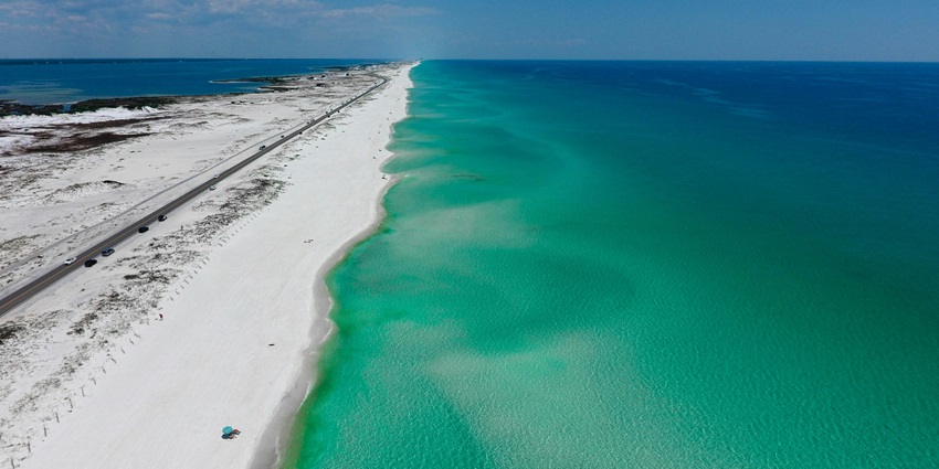 An awe-inspiring view of turquoise-blue waters meeting the pristine white sands.