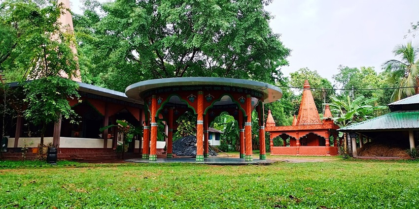 Central Tapoban Ashram structure amidst greenery, pillared open pavilion.