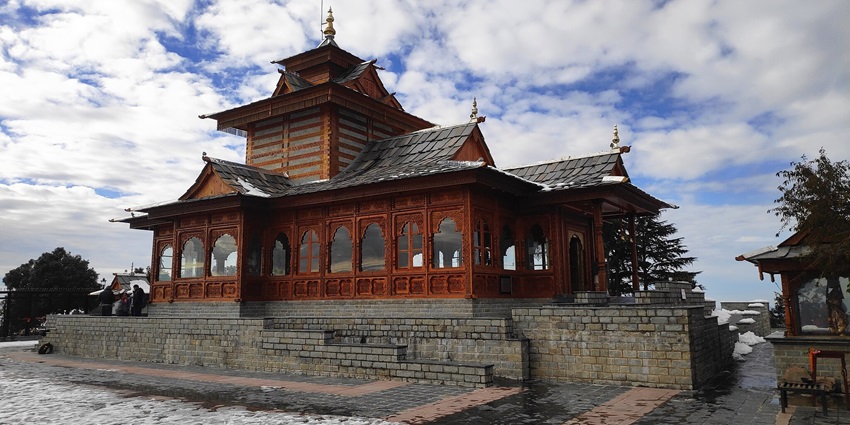 A serene view of the revered Tara Devi temple in Shimla on a clear day amidst clouds