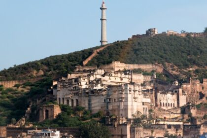 A wide angle view of the Taragarh Fort, situated on top of the rocky hill during the day.