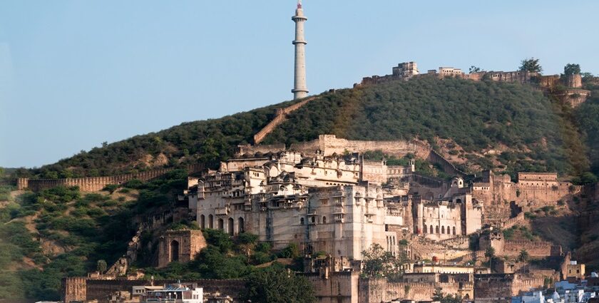 A wide angle view of the Taragarh Fort, situated on top of the rocky hill during the day.