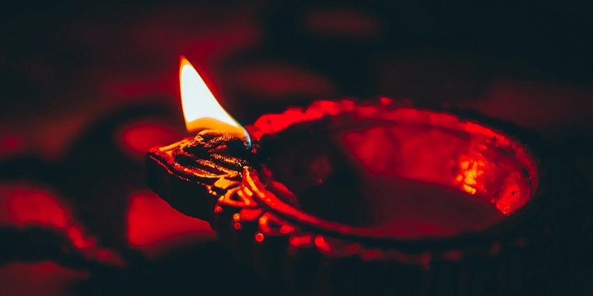 A closeup view of a diya lit up in a sacred site like Tarkeshwar Mahadev Mandir in Jaipur.