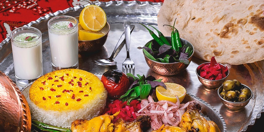 Traditional Indian thali served on a silver plate with meat, vegetables, and chutneys.