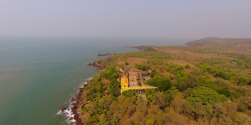Aerial view of Terekhol Fort surrounded by lush greenery near the beach during day time