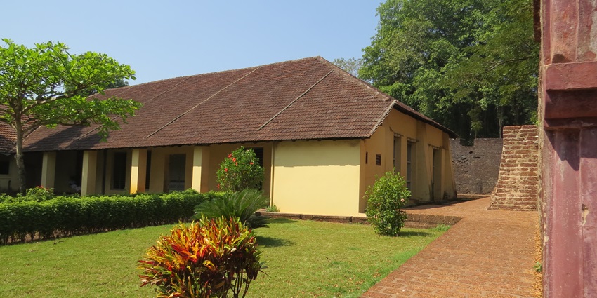 A low-angle view of the famous Thalassery building, featuring a towering lighthouse.