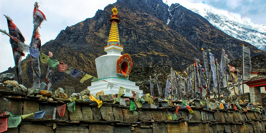 A breathtaking view of a white gompa in Himachal Pradesh with flags around it in the day.