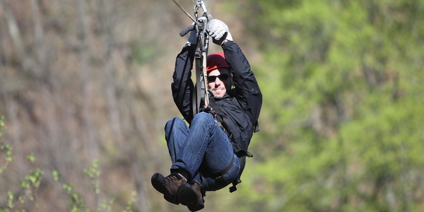 Man soaring on a zip line, experiencing the thrill of The Adventure Lab in Rajasthan.