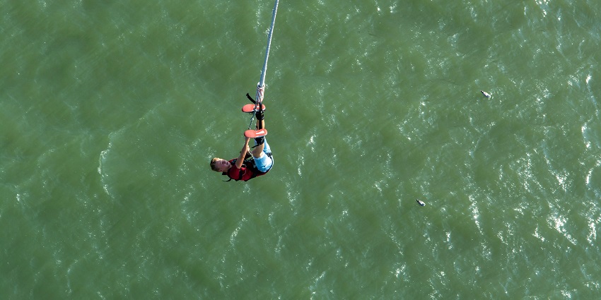 Man falling into the ocean, captured mid-air enjoying bungee jumping in Kathmandu.