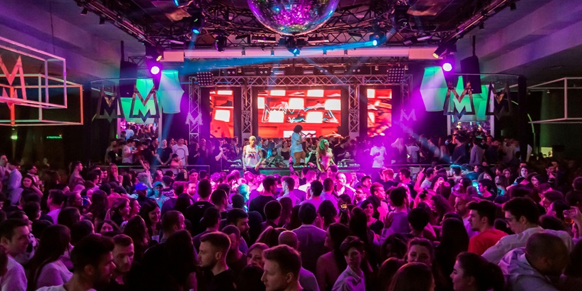 A dance floor at The Clubhouse with people enjoying a DJ performance with live music.