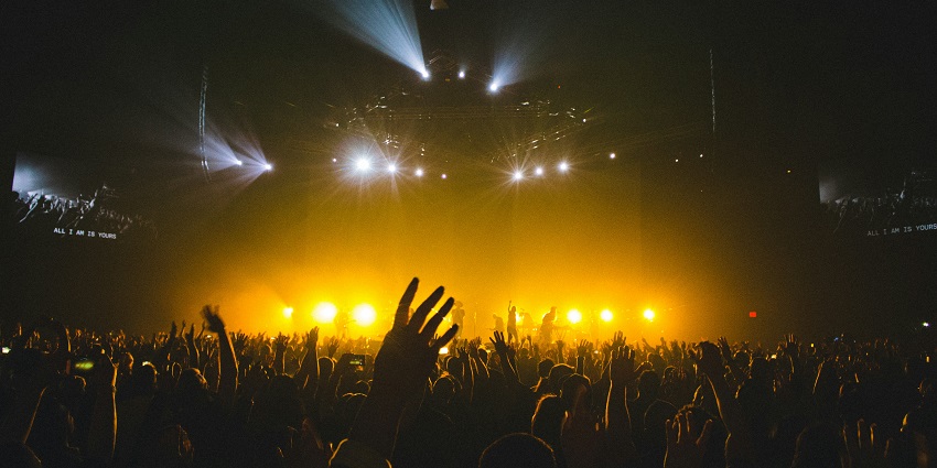 A crowd of people dancing under the glistening yellow lights at the Gateway Resort.