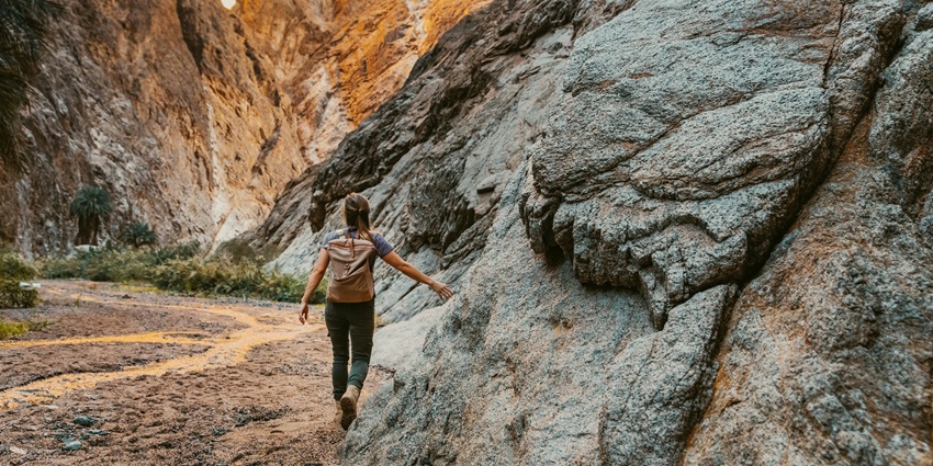 A person walking along rugged mountains at one of the best adventure parks in Udaipur.
