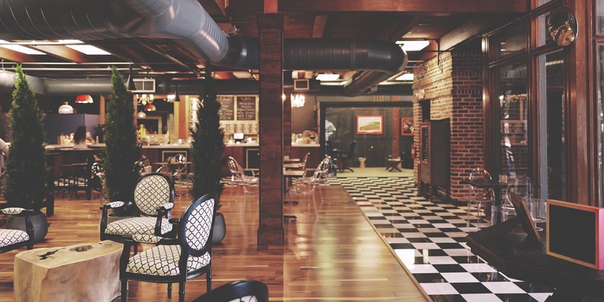 A view of an elegant restaurant interior with modern furniture and low yellow lights.