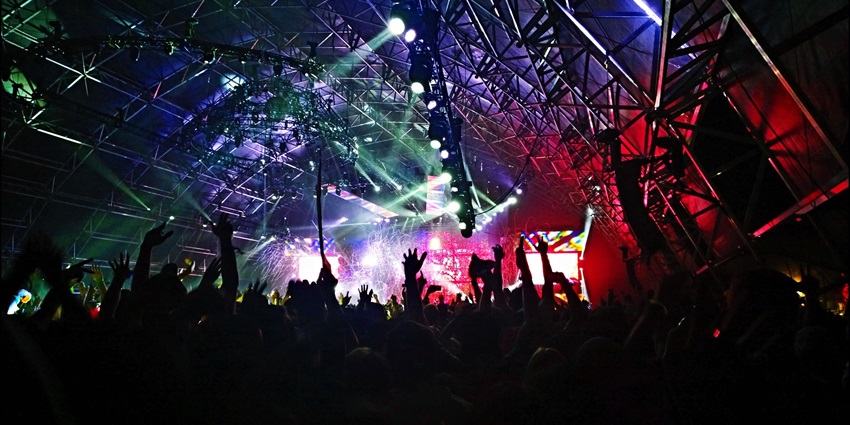 Excited audience enjoying a live band performance at a concert venue during the evening.