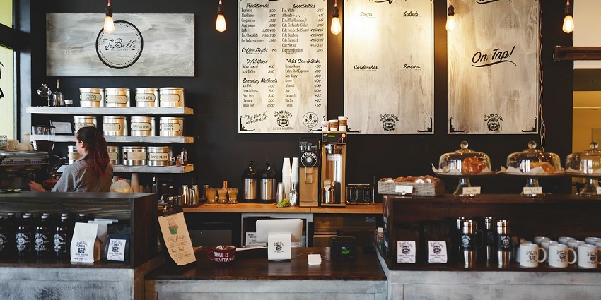 A picture of a quiet cafe in Pushkar, with a woman working behind the counter