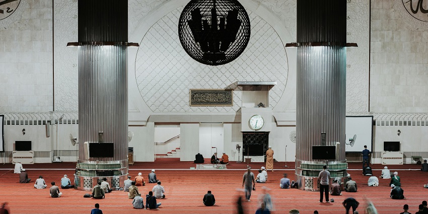 Picture of people sitting inside a huge prayer hall, among the popular mosques in Jaipur.