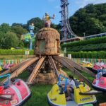 A picture of a merry-go-round ride in an amusement park with children enjoying