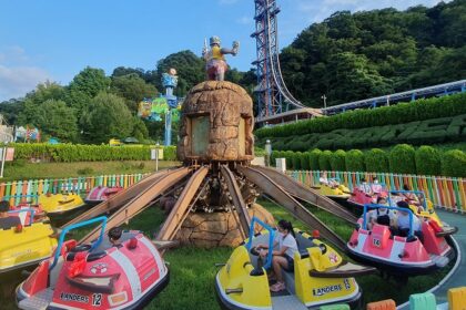 A picture of a merry-go-round ride in an amusement park with children enjoying