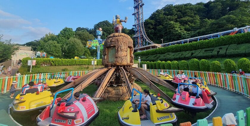 A picture of a merry-go-round ride in an amusement park with children enjoying