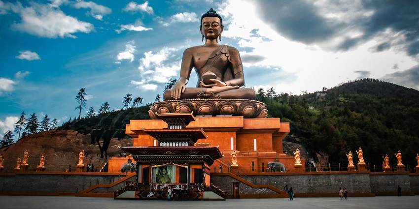 A breathtaking view of a golden statue in Bhutan surrounded by enchanting meadows.