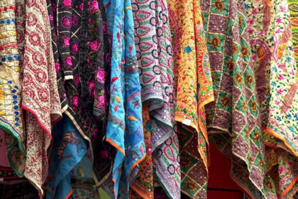 An image of the bustling market with pashmina scarves on display at a store.