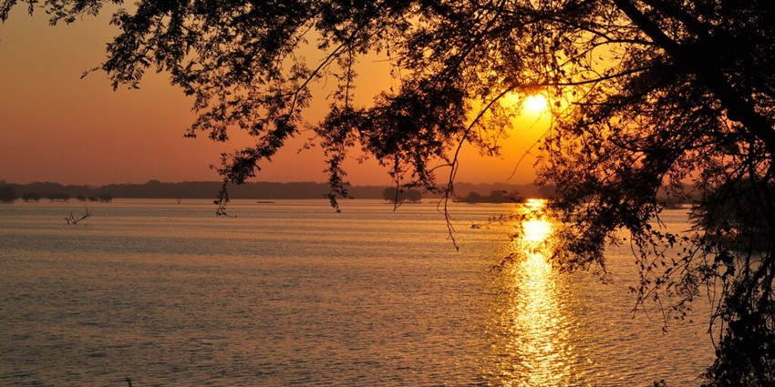 Sunset overlooking a body of water at Thol Lake Bird Sanctuary, near Shanku water park