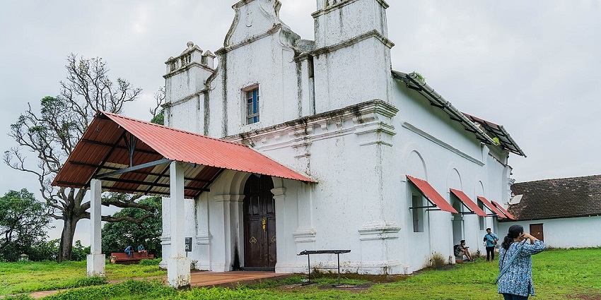 A picture of a famous chapel in Goa with a garden area surrounding it